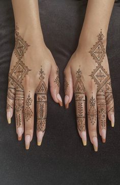 two hands with hendi designs on them