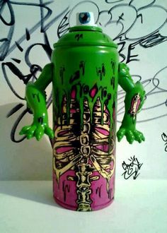 a green and pink can with graffiti on it