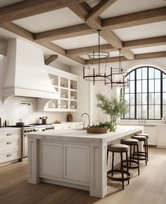 a large kitchen with white cabinets and wooden beams on the ceiling, along with an island