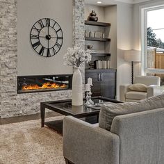 a living room filled with furniture and a clock mounted to the wall over a fire place