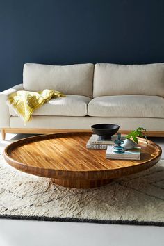 a living room with a couch, coffee table and rug on the floor in front of it