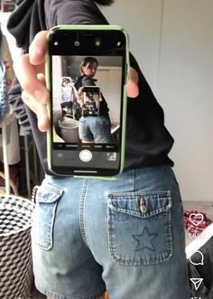 a man holding up his cell phone to take a selfie with the image of himself