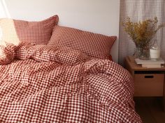 a red and white checkered comforter on a bed