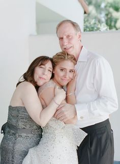 a man and two women hugging each other