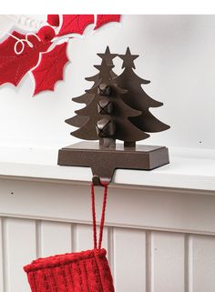 a christmas stocking hanging on a mantle with a small tree in the corner and an ornament attached to it