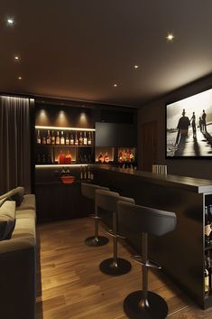 a home bar with stools in front of it and a television on the wall