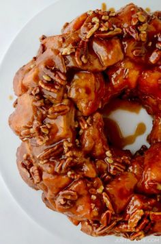 a bundt cake covered in caramel and nuts on a white plate with a fork