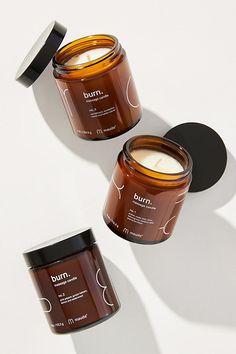 three jars of body butter sitting next to each other on a white surface with shadows