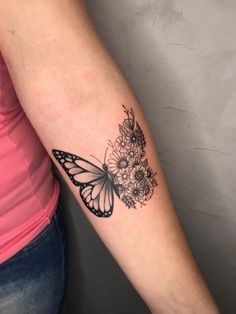 a woman's arm with a butterfly and flowers tattoo on the left inner arm