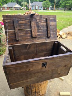 an old wooden box with chains hanging from it's sides sitting on top of a tree stump