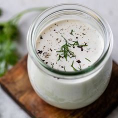 a glass jar filled with white liquid on top of a wooden board