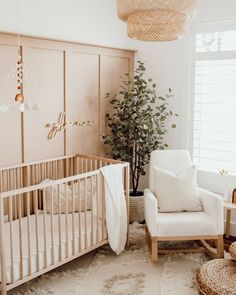 a baby's room with a crib, rocking chair and potted plant