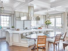 a large kitchen and dining room with white walls, wood flooring and wooden floors