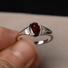 This is a gorgeous handmade creation. Its beauty is its simplicity & Elegance. The 6*8mm oval shape faceted natural garnet is crafted in solid sterling silver and with rhodium plated. All item is sent in a beautiful gift box If you have any idea of design your ring,pls contact me directly. You can realize more lovely stuff clicking the link https://www.etsy.com/shop/knightjewelry?refshopsection_shophome_leftnav Please leave the correct address and you phone number for delivering successfully Oval Garnet Rings For Anniversary, Oval Garnet Birthstone Ring As Gift, Oval Garnet Birthstone Ring, Oval Garnet Birthstone Ring For Anniversary, Silver Oval Garnet Birthstone Ring, Oval Silver Garnet Birthstone Ring, Oval Garnet Birthstone Ring In Silver, Oval Garnet Ring In Silver, Oval Cabochon Garnet Rings For Anniversary