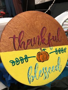 a wooden sign that says, thank you all and has a painted pumpkin on it