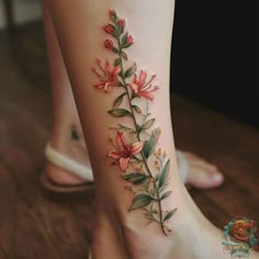 a woman's foot with flowers and leaves tattoo on the side of her leg