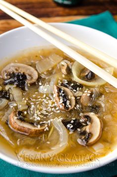 a white bowl filled with soup and chopsticks