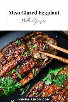 grilled eggplant on a black plate with chopsticks and parsley