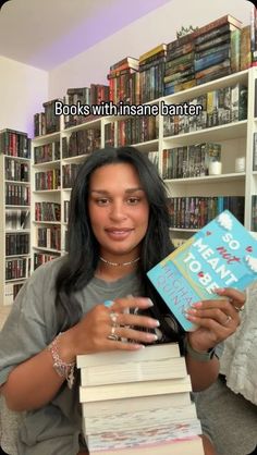 a woman sitting on a couch holding a stack of books