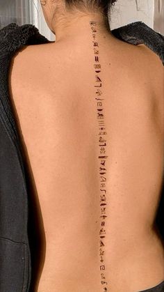 the back of a woman's neck with words written on her upper and lower back