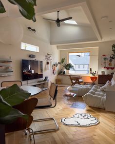 a living room filled with furniture and a flat screen tv on top of a wooden floor