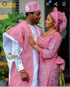 a man and woman dressed in pink standing next to each other with their arms around each other