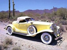 an old yellow car is parked in the desert