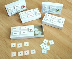 four matching cards in a box on a wooden table with letters and numbers cut out