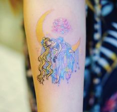 a woman's arm with a watercolor painting on it and a crescent moon