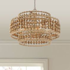 a wooden beaded chandelier hangs from the ceiling in a room with windows