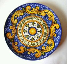 a decorative blue and yellow plate on a white surface