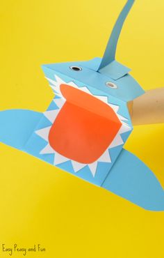 someone is cutting out an origami shark