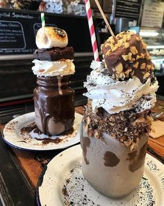 two desserts sit on plates next to each other in front of a bakery counter