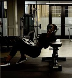 a man laying on top of a bench next to a barbell machine in a gym