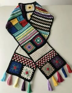 two crocheted scarves with tassels and fringes on them, one is multicolored