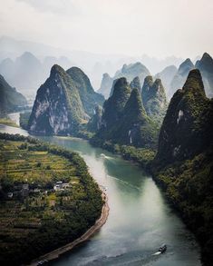 an aerial view of the river and mountains in china, with a boat on it's side