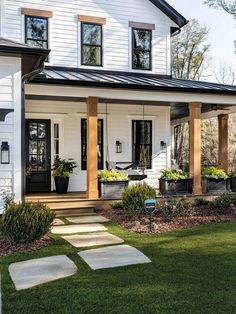 a white house with a red pin on it's front door and steps leading up to the porch