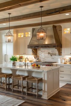 a large kitchen with an island in the middle and two pendant lights hanging from the ceiling