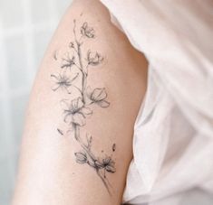 a woman with a flower tattoo on her left arm and right arm behind her back