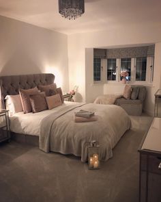 a bedroom with a bed, chair and chandelier on the wall next to it