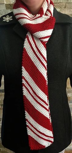 a woman wearing a red and white striped knitted scarf with a black shirt underneath