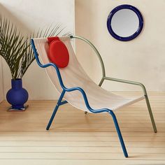 a white chair sitting in front of a mirror next to a potted palm tree