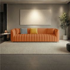 an orange couch sitting in a living room next to a table