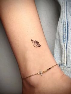 a woman's arm with a small butterfly tattoo on the left side of her arm