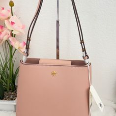 Band New With Tag Style Number: 134840 Material: Saffiano Leather, Canvas Lining Closure: Magnetic Snap Closure Interior: Canvas Lining, 1 Front Slip Pocket, 1 Back Slip Pocket And 1 Back Zipper Pocket Bag Size: 9.5" (L) X 9.25" (H) X 4.75" (D) Strap: Adjustable Crossbody Leather Strap With 19.5" Drop; Can Be Adjusted To 10.25" When Worn As Shoulder Bag. Color:Light Meadowsweet(Pink) Elegant Tan Bucket Shoulder Bag, Elegant Tan Bucket Bag, Elegant Pink Bucket Bag For Formal Occasions, Pink Saffiano Leather Formal Shoulder Bag, Formal Pink Saffiano Leather Shoulder Bag, Tory Burch Emerson, Tory Burch Bags, Tory Burch Bag, Pocket Bag