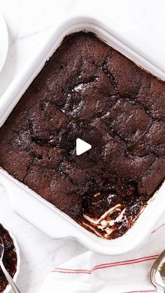 a brownie in a white baking dish on a table