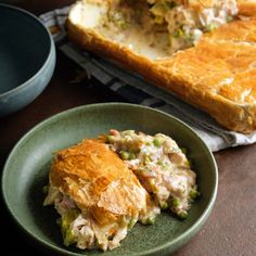 a green plate topped with food next to a loaf of bread