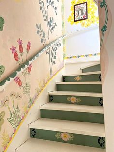 the stairs are painted with flowers and plants on them, along with a framed picture