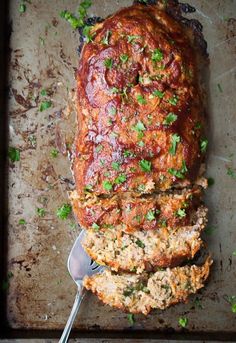 meatloaf on a baking sheet with a serving spoon