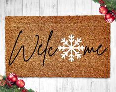 a welcome mat with a snowflake on it and christmas decorations around the edges